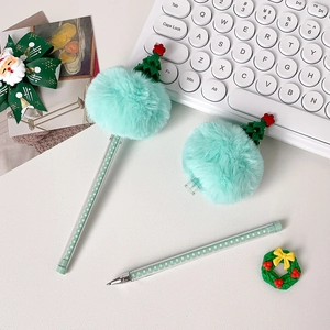 Detail of light green Christmas tree ballpoint pen with pom pom and polka dot patterns