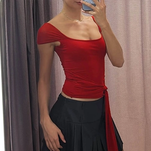 Detail of red square-neck slim top featuring side lace-up tie waist and open back