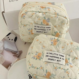 Quilted cream floral pouch set with tiny orange and blue flowers for cosmetics