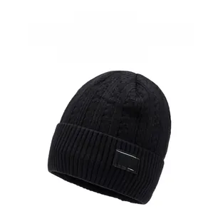 Detail of black knitted beanie showing thick ribbed texture and brand label for winter