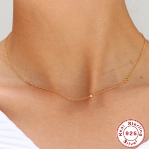 Collier lettre S en argent 925 plaqué or avec zircon sur un cou élégant de femme