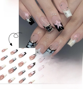 Close-up of ballet style press-on nails with black white tips and pink star details