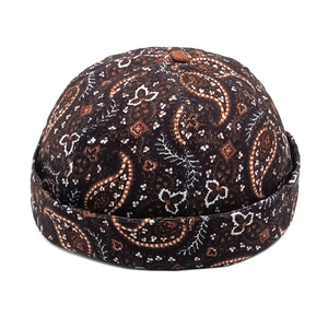 Close-up of vintage paisley pattern on brown corduroy docker cap with folded brim