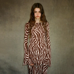 Detail shot of long sleeve zebra print dress with flared cuffs on a grey background
