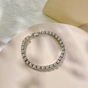 Bohemian silver tennis anklet with 26 letters and clear zircon crystals on beige stand