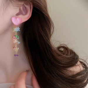 Gros plan de boucles d'oreilles cœur en cristal avec pierres colorées sur un mannequin