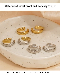 Close-up of gold and silver hoop earrings on ceramic plate with polished finish