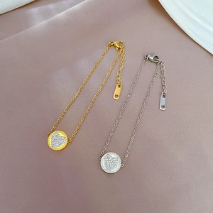 Macro view of gold and silver titanium steel heart pendants with shimmering rhinestones