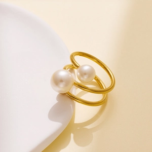 Detail view of a vintage golden double-ring design with pearls on a ceramic dish