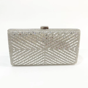 Close-up of elegant silver clutch purse featuring geometric X-pattern rhinestone crystal texture