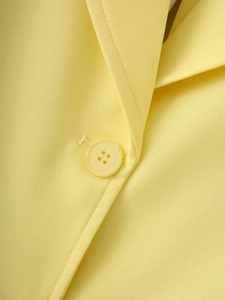 Detail of bright yellow satin blazer lapel and button showing fine twill texture