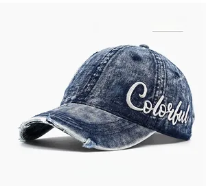Close-up of distressed denim baseball cap with frayed edges and 3D colorful embroidery