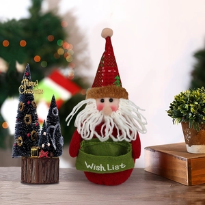 Festoso Babbo Natale con sacchetto dei desideri accanto a un mini albero di Natale