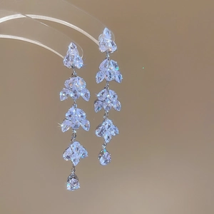 Detail view of silver tassel earrings with crystal leaves and teardrop pendants