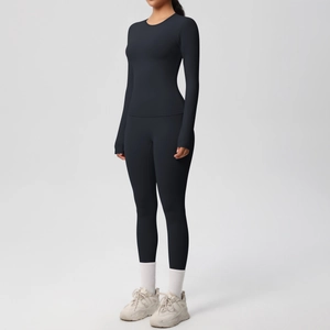 Dettaglio del tessuto nero opaco elastico su maglia yoga a maniche lunghe e leggings