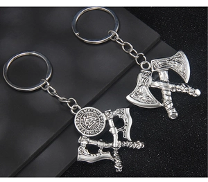 Detail view of two silver Viking axe keychains with runic engravings and Valknut symbols