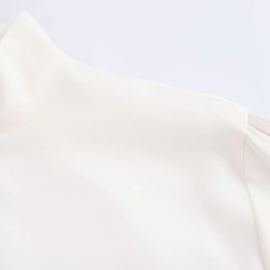 Detail view of high-quality fabric texture on stand collar and shoulder of the two-piece set