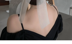 Detail of elegant black tulle bow hair clip worn by model for half-up hairstyle