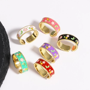 Flat lay of colorful enamel floral rings in red, pink and black on white background
