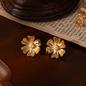French daisy pearl stud earrings in gold titanium steel on a vintage wooden background