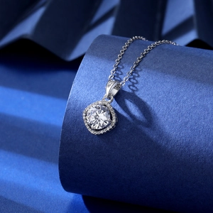 Macro shot of 2ct cushion cut zircon pendant on silver chain over blue backdrop