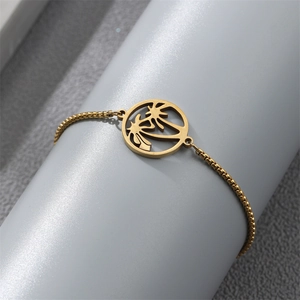 Detail of a gold palm tree pendant bracelet with adjustable chain on a model stand