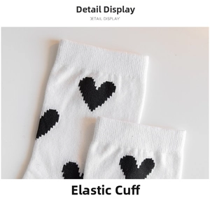 Macro shot of white ribbed cuff and black heart jacquard pattern on cotton socks