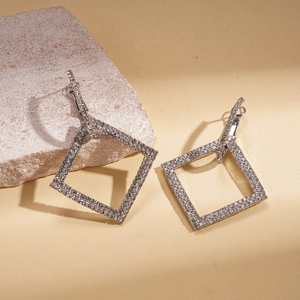 Detail shot of silver square hoop earrings with crystal pavé on textured stone base