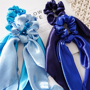 Close-up of light and dark blue satin silk hair scrunchies with long ribbon streamers
