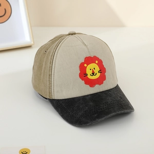 Detail of kids baseball cap featuring a cartoon lion print and washed contrast brim