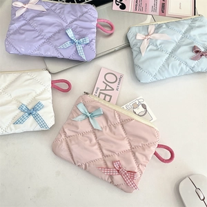 Close-up of quilted nylon cosmetic bags in pastel colors with decorative bows