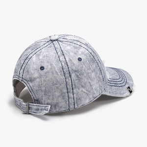 Distressed blue washed denim baseball hat with ripped details and metal logo plate