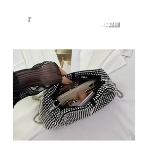 Detail view of rhinestone evening bag interior capacity for smartphone and makeup essentials