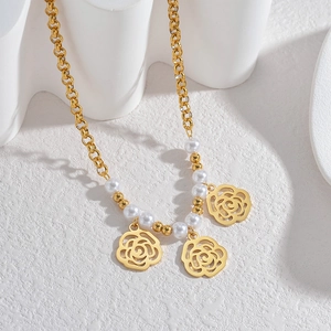 Collier de perles minimaliste plaqué or avec trois pendentifs roses évidés sur chaîne