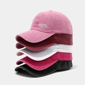 Five assorted colors of embroidered washed cotton baseball caps stacked vertically