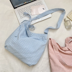 Detailed flat lay of light blue and pink gingham canvas tote bags with wide straps