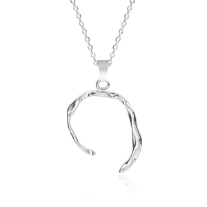 Macro shot of an irregular organic silver pendant with a sleek, polished metallic texture