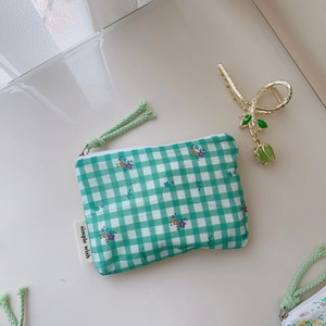 Détail du petit sac en coton à carreaux verts et blancs avec fermeture éclair blanche