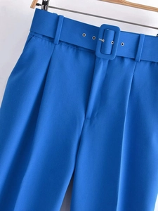 Detalle de pantalón azul de cintura alta con cinturón de tela a juego y hebilla plateada