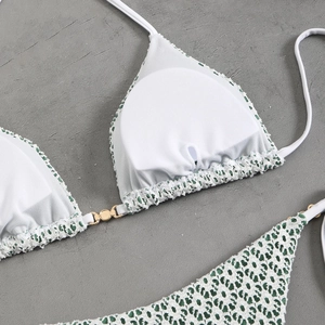 Detail of green and white crochet bikini set with gold buckles and side tie bottoms