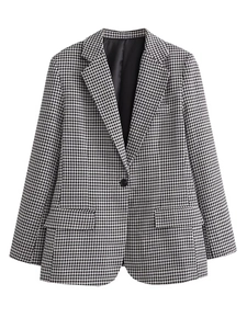 Detail of single-button closure and classic houndstooth weave on a women's blazer