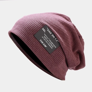 Gros plan du bonnet bordeaux en maille gaufrée avec détail d'étiquette noire tissée