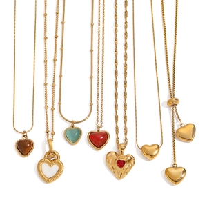 Golden stainless steel heart pendant necklace collection with gemstones on white background