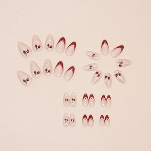 Faux ongles amande faits main avec motifs cerises, perles et design French tip