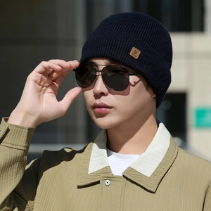 Close-up of navy blue knit beanie with a brown leather logo patch for men's winter wear