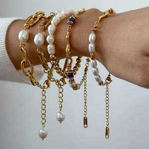 Elegant multi-layered gold stainless steel bracelet set with pearls on a female wrist