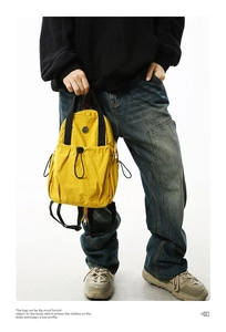 Detail view of yellow lightweight nylon backpack with functional straps for street style