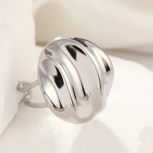 Macro shot of silver pleated titanium steel ring on soft fabric with metal texture