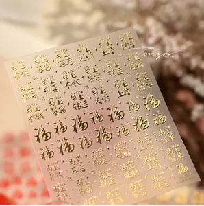 Macro shot of 3D gold embossed nail stickers with Chinese fortune characters and zodiac motifs