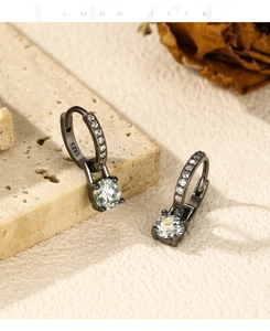 Macro detail of S925 silver black hoop earrings with moissanite drop on stone base